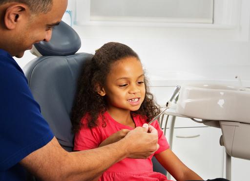 Young girl looking calm whilst talking to a dentist