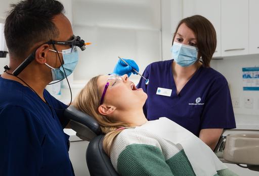 Lady receiving dental treatment supported by two professionals from the Blockley Partnership.